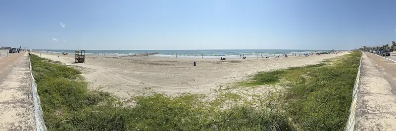 Panoramic view of the beach and dune grass from the seawall in Galveston