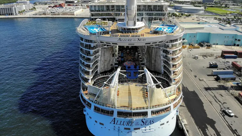 A large cruise ship docked at a cruise terminal on a sunny day