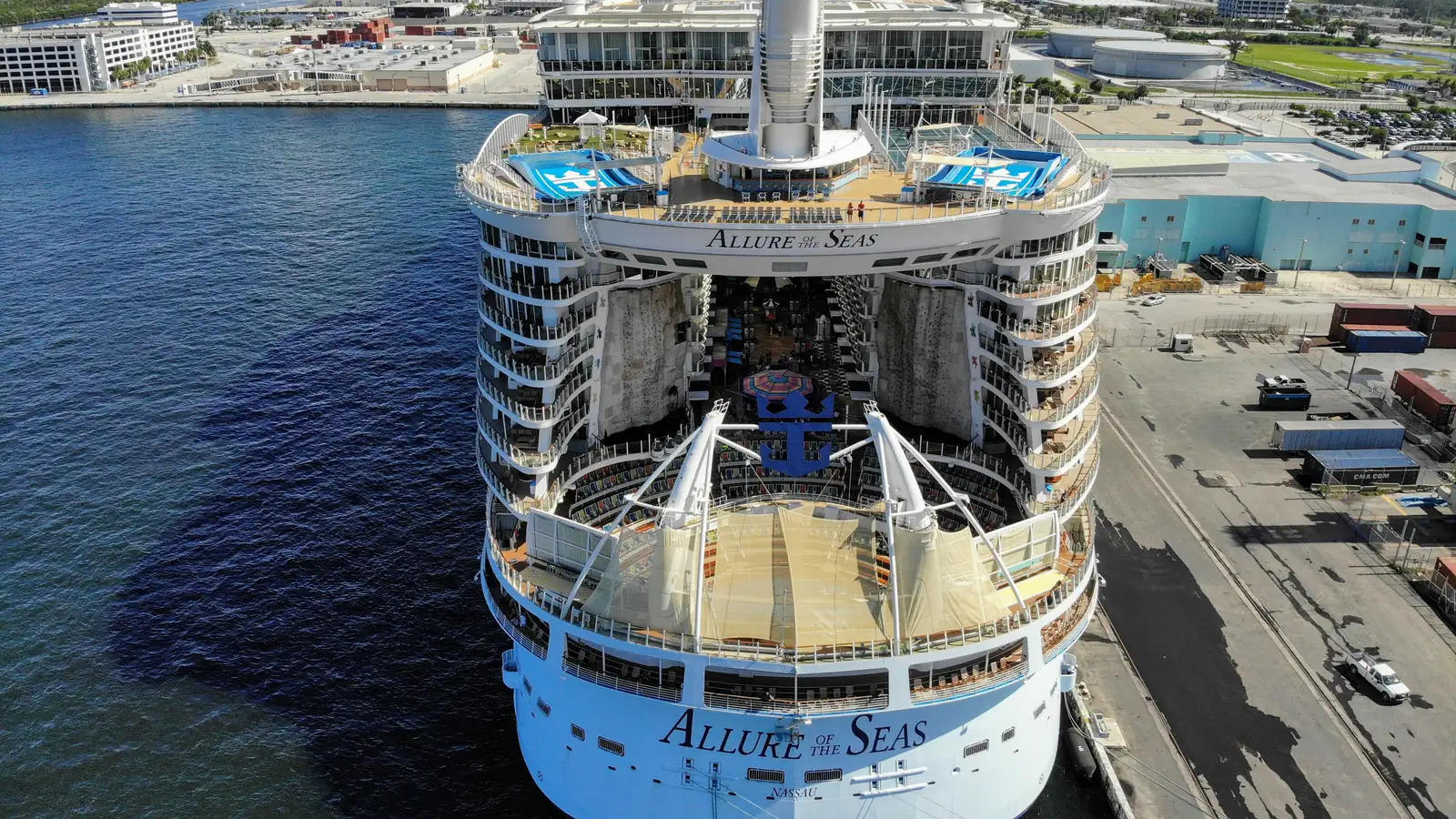 A large cruise ship docked at a cruise terminal on a sunny day