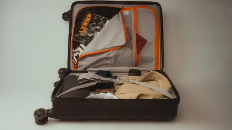 Open black suitcase packed with clothes and travel essentials