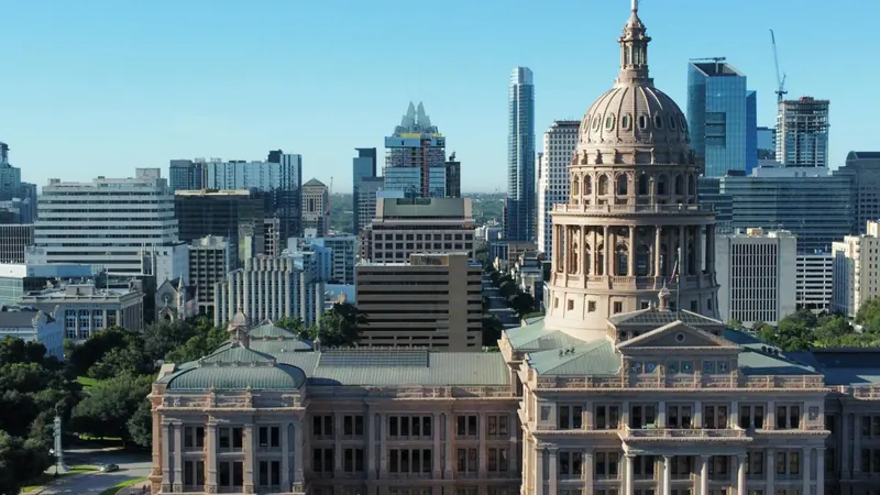 Texas State Capitol dome with the downtown Austin skyline behind it
