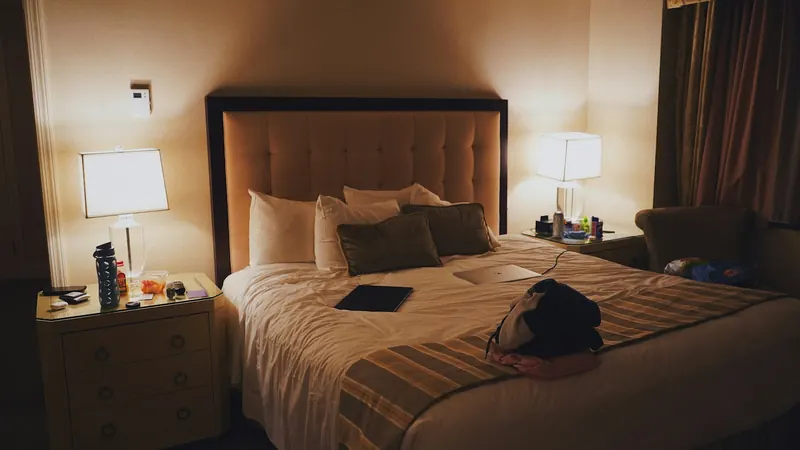 Hotel room with a suitcase on the bed and bedside lamps glowing