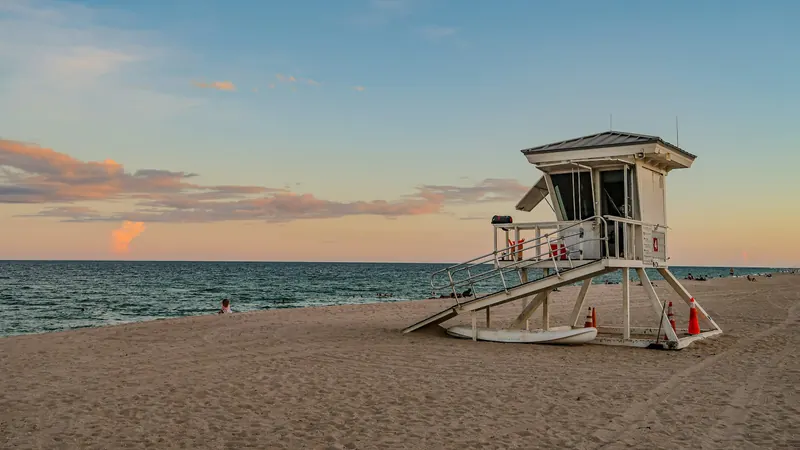 Lifeguard stand on a wide sandy beach at sunrise