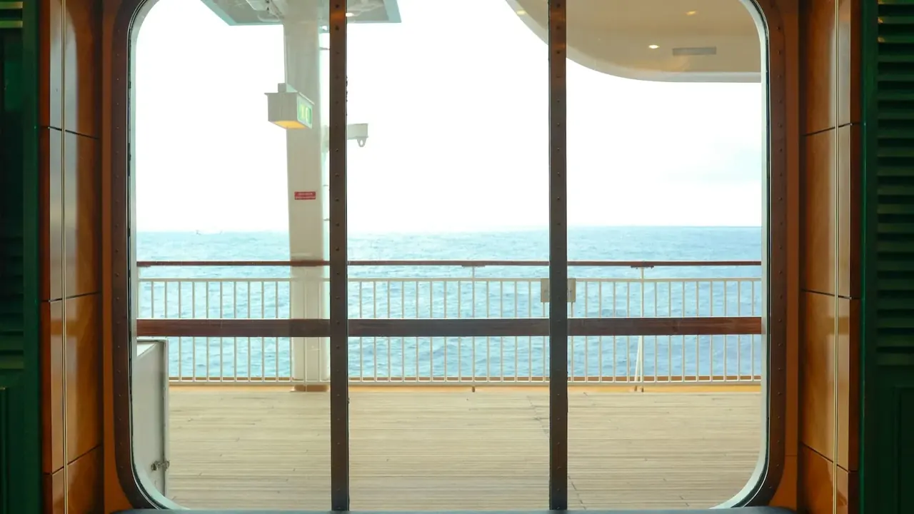 Ocean view through the open balcony door of a cruise ship cabin