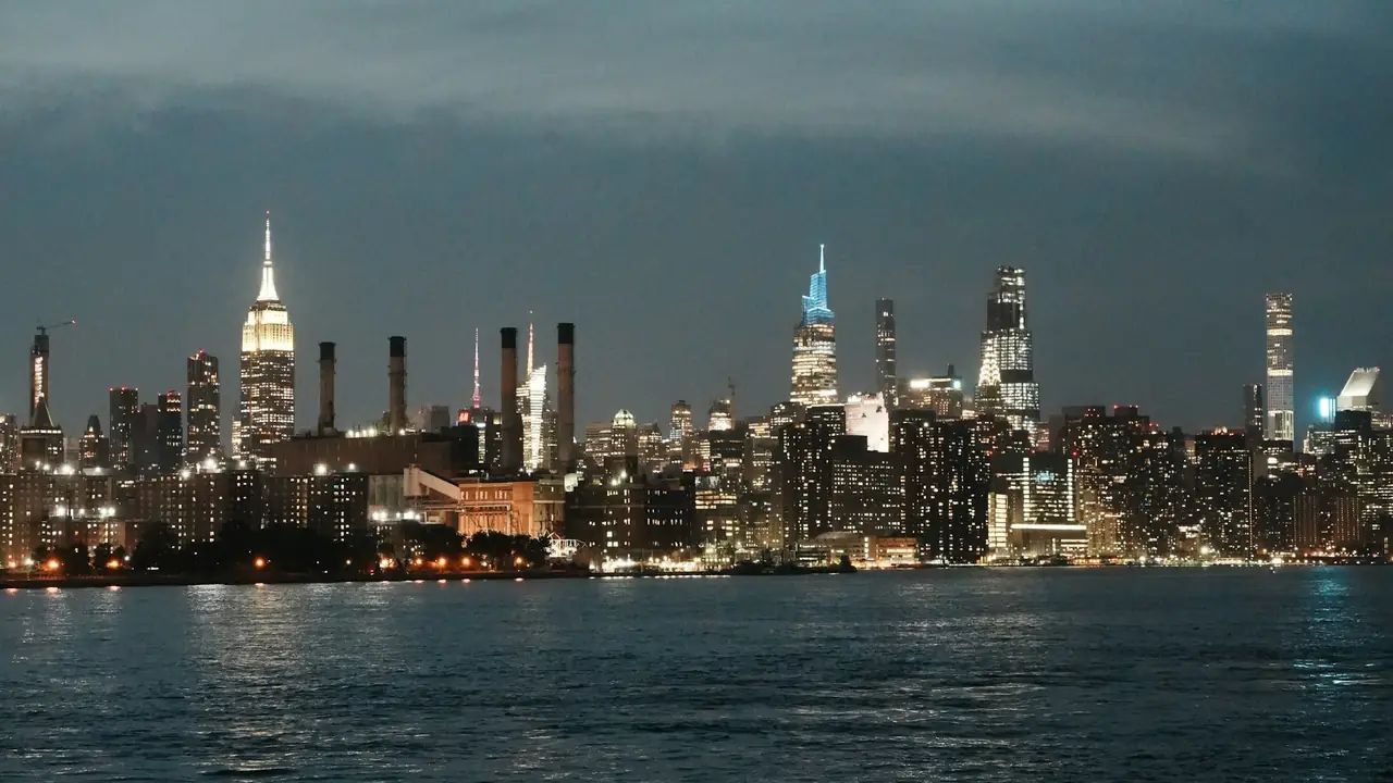 New York City skyline lit up at dusk across the water