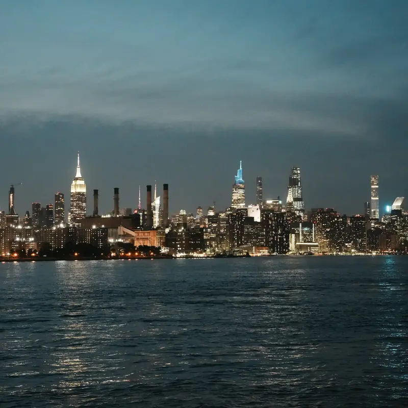 New York City skyline lit up at dusk across the water